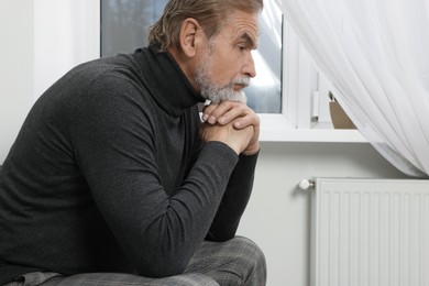 Photo of Upset senior man on sofa at home. Loneliness concept