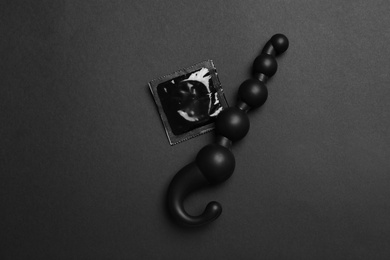 Anal ball beads and condom on black background, top view. Sex game