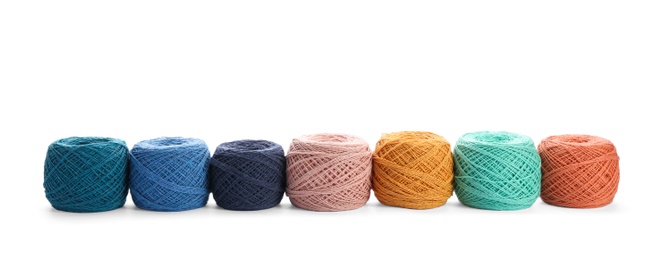 Photo of Clews of colorful knitting threads in row on white background