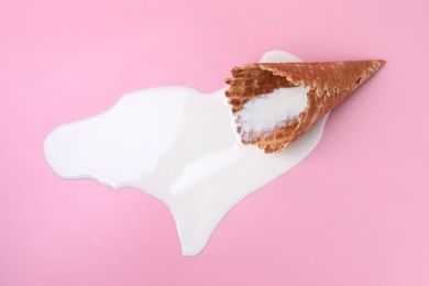 Photo of Melted ice cream and wafer cone on pink background, above view