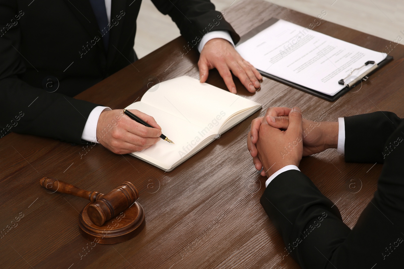 Photo of Law and justice. Lawyers working with documents at wooden table, closeup