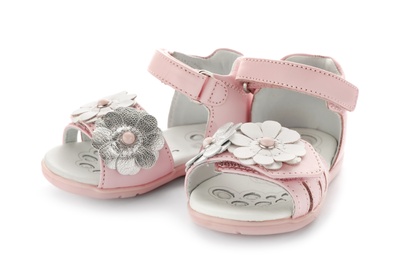 Photo of Pair of pink baby sandals decorated with flowers on white background