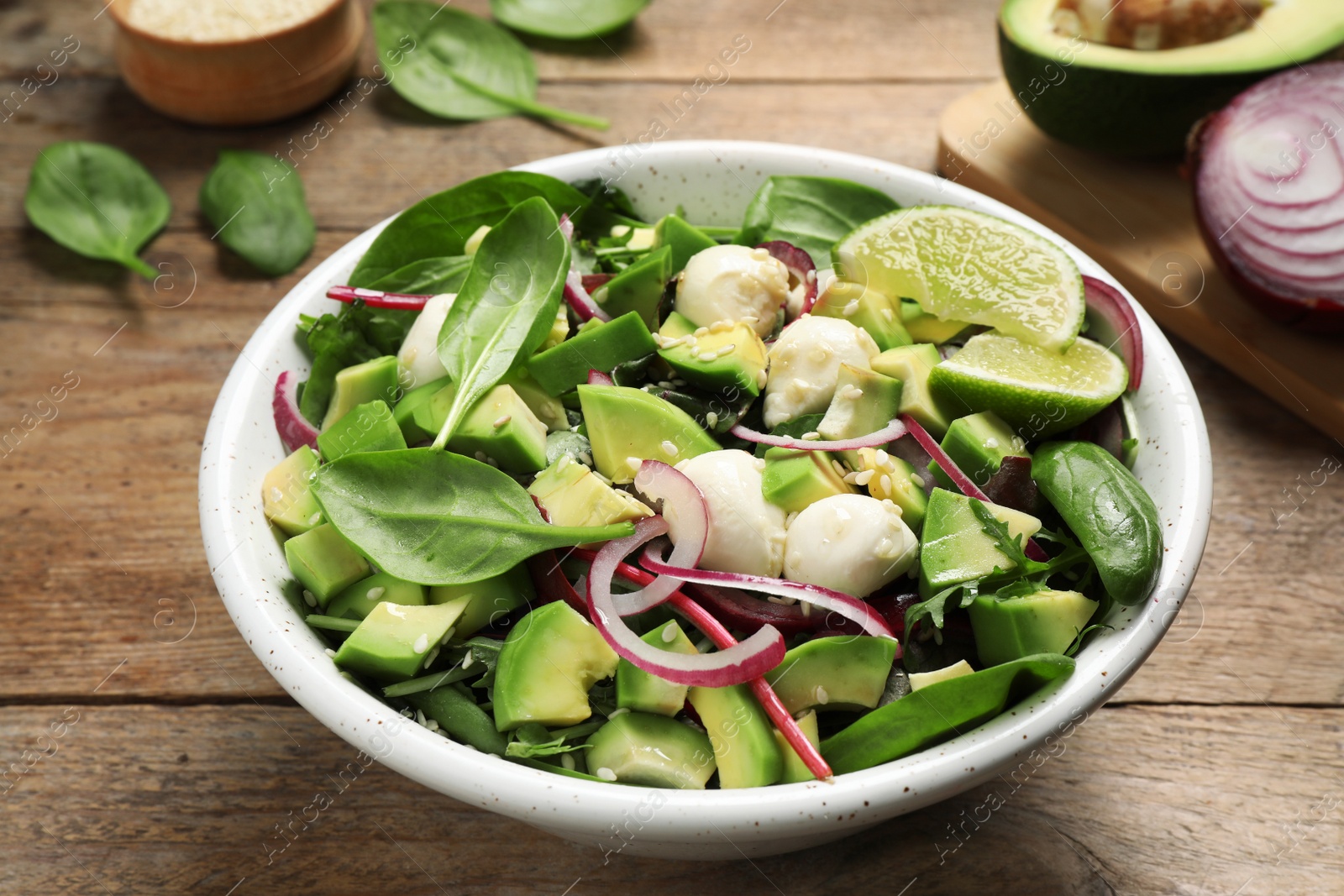 Photo of Delicious avocado salad with mozzarella on wooden table