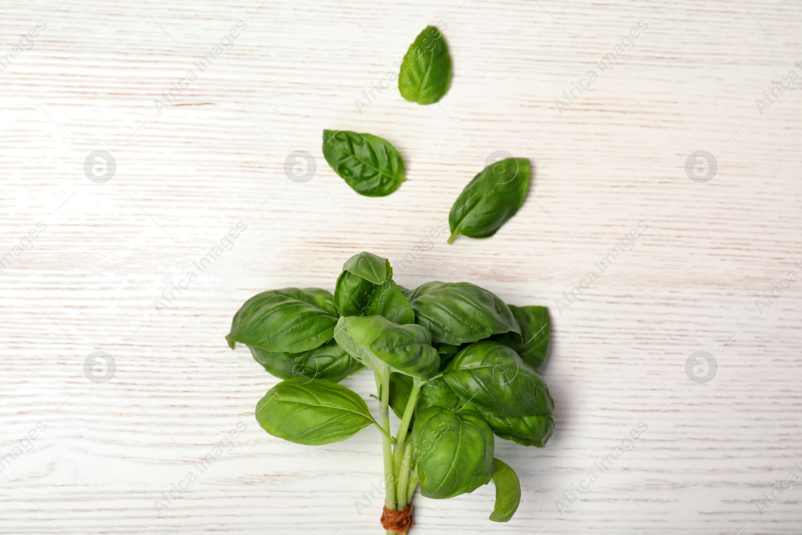 Photo of Bundle of fresh green basil and leaves on wooden background, top view