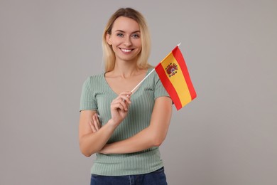 Photo of Happy woman with flag of Spain on grey background