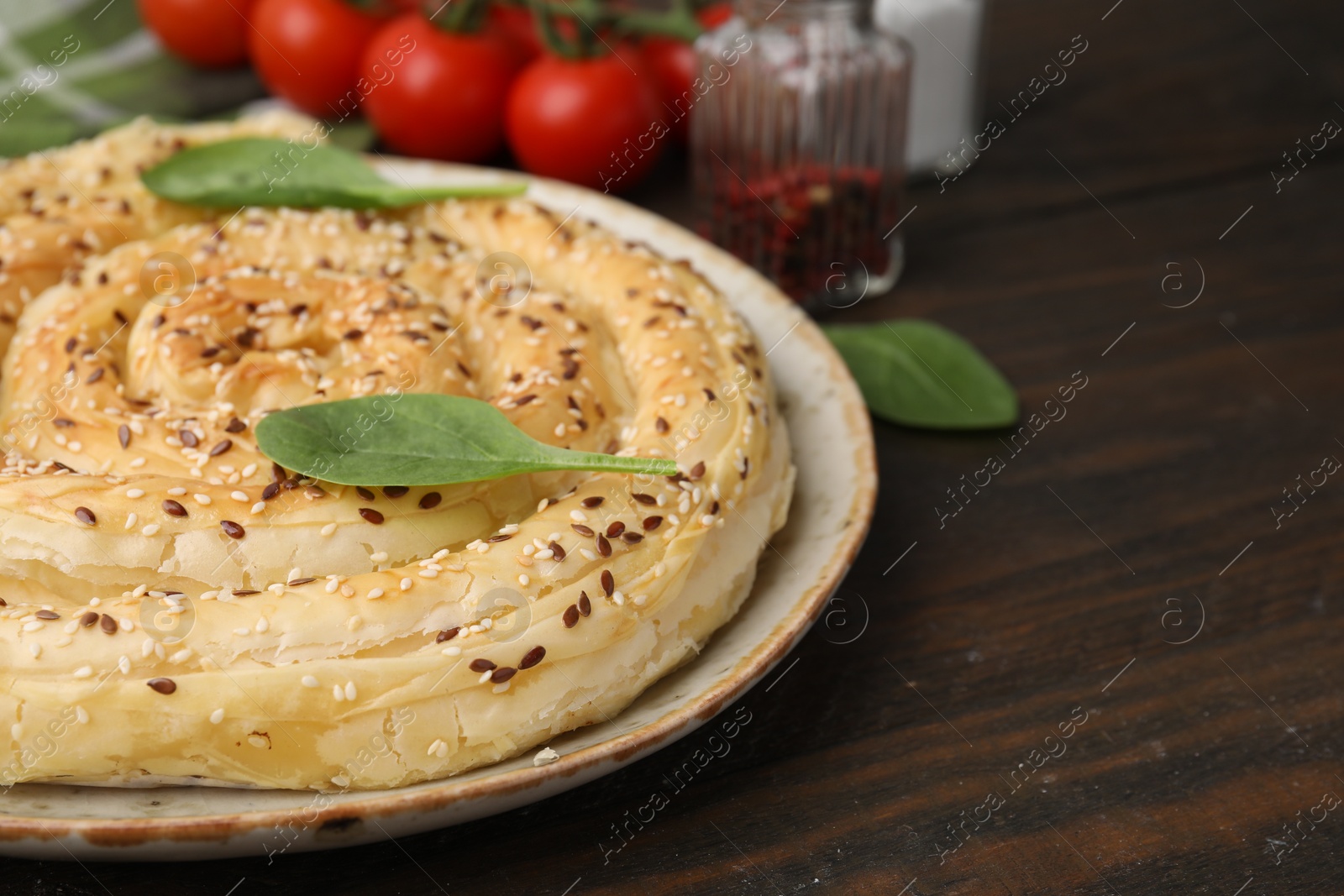 Photo of Delicious puff pastry with spinach on wooden table, closeup