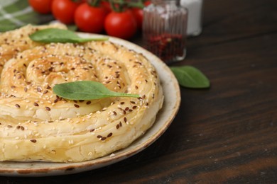 Photo of Delicious puff pastry with spinach on wooden table, closeup