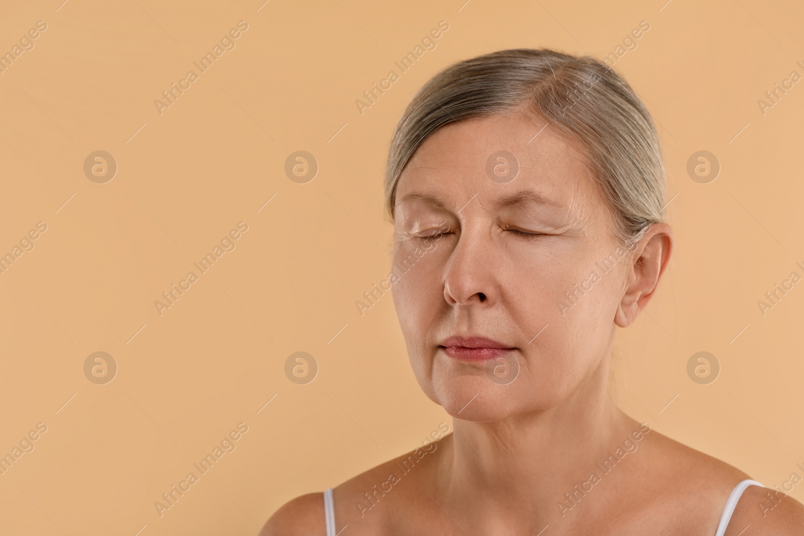 Photo of Woman with closed eyes on beige background, space for text