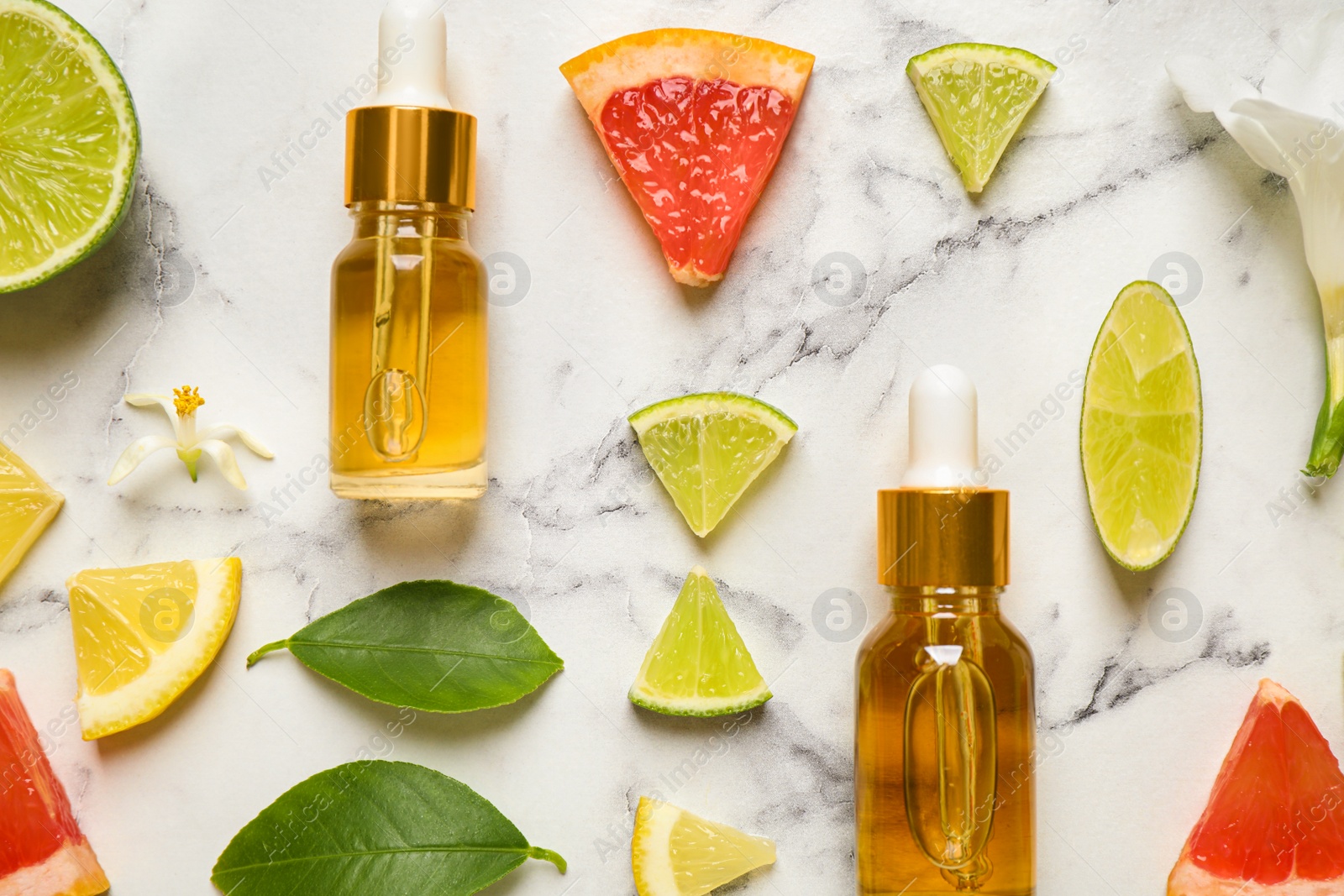 Photo of Flat lay composition with bottles of citrus essential oil on white marble background