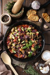 Delicious ratatouille in baking dish served on wooden table, flat lay