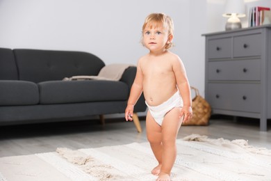 Photo of Cute baby learning to walk in living room