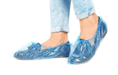 Photo of Woman with blue shoe covers worn over loafers on white background, closeup