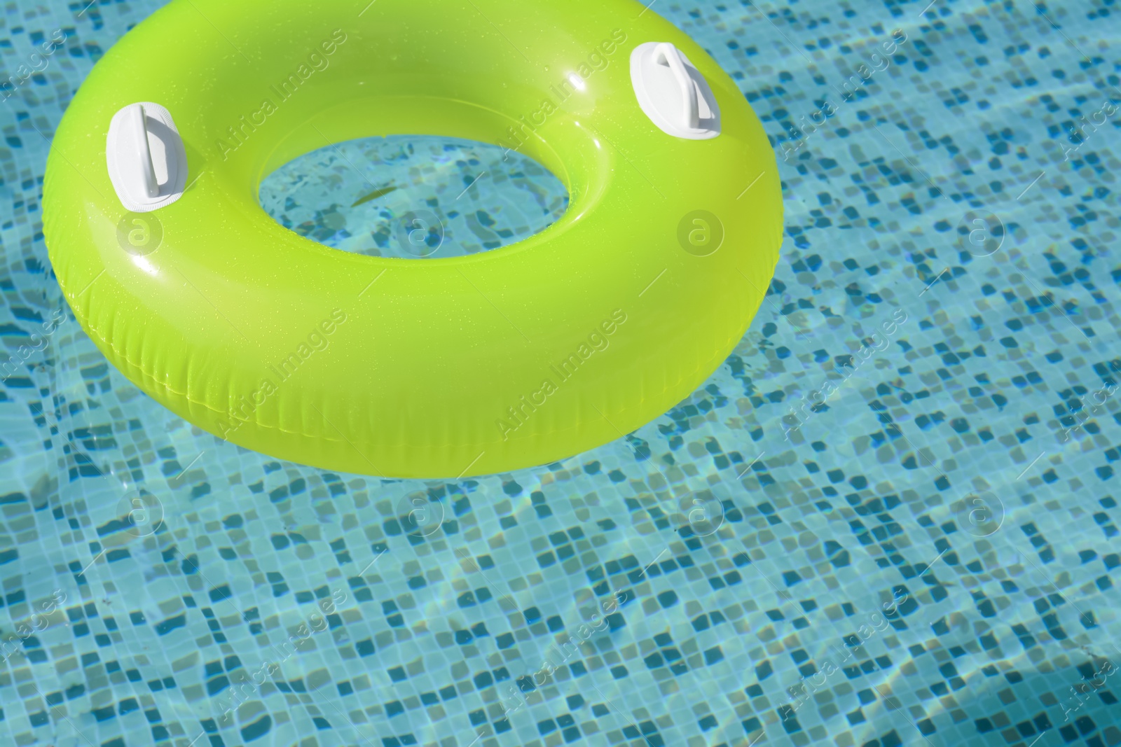 Photo of Light green inflatable ring floating in swimming pool