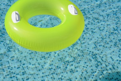 Photo of Light green inflatable ring floating in swimming pool