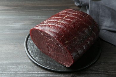 Plate with tasty bresaola on wooden table, closeup