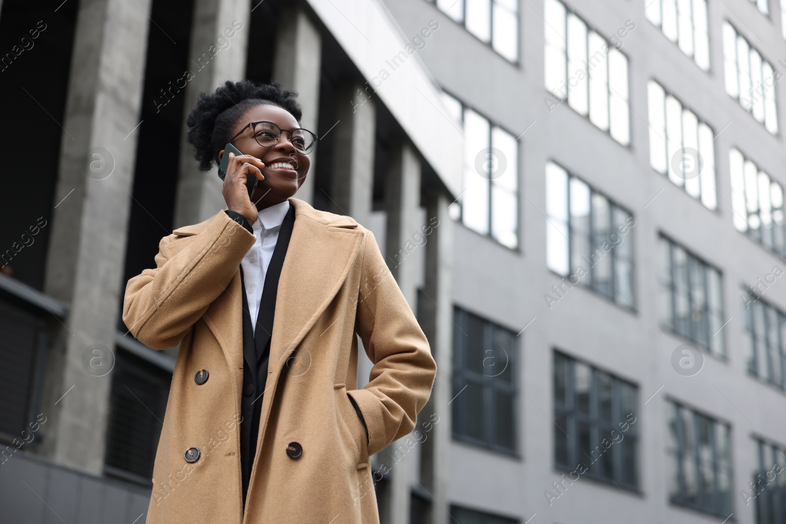 Photo of Happy woman talking on smartphone outdoors, space for text. Lawyer, businesswoman, accountant or manager