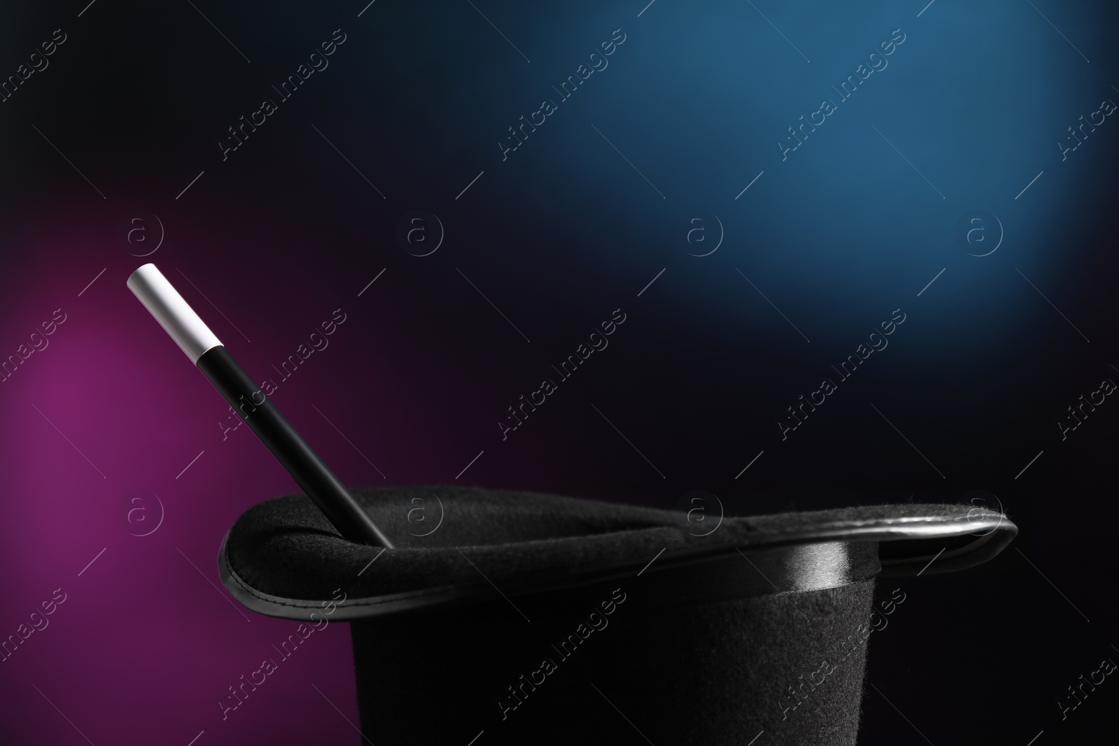 Photo of Magician's hat and wand on dark background, closeup