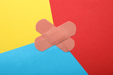 Sticking plasters on color background, top view
