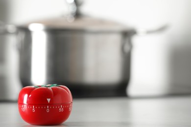 Kitchen timer in shape of tomato on white table indoors. Space for text