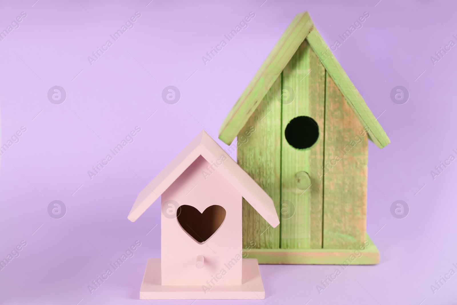 Photo of Beautiful wooden bird house on violet background