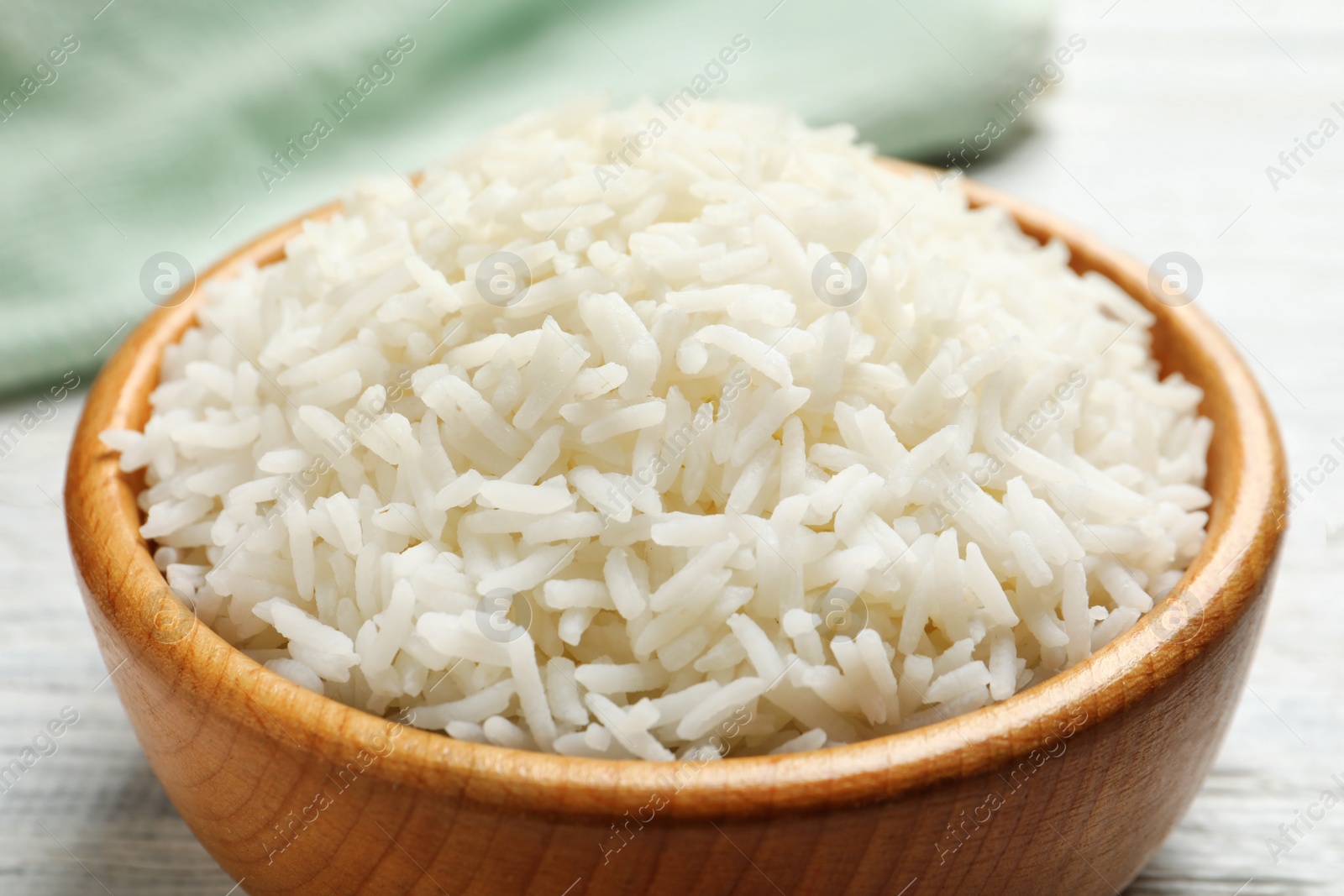 Photo of Bowl of tasty cooked white rice on table, closeup