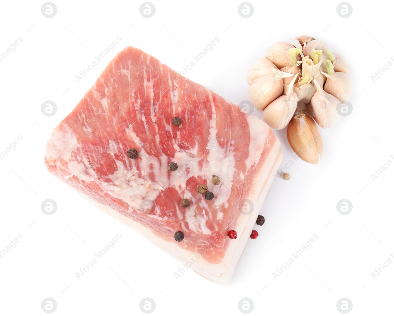 Photo of Piece of pork fatback with peppercorn and garlic isolated on white, top view