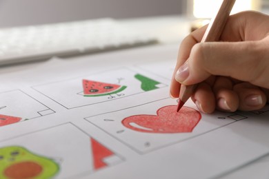 Photo of Woman drawing cartoon sketch at workplace, closeup. Pre-production process