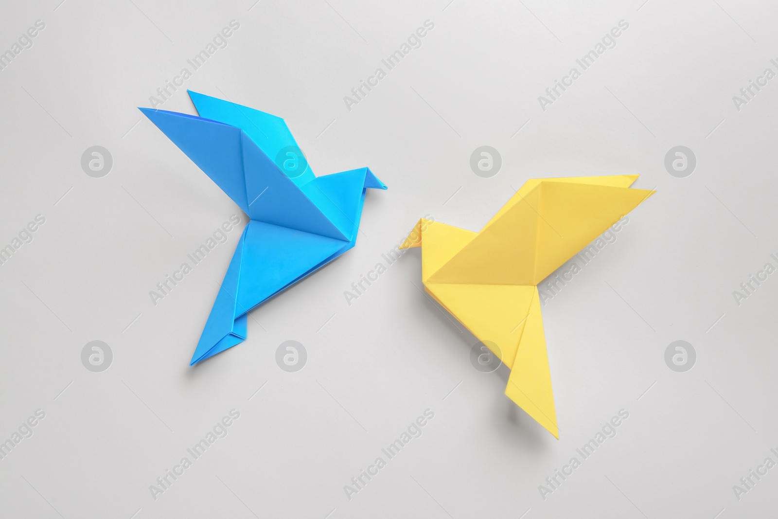 Photo of Beautiful colorful origami birds on white background, flat lay