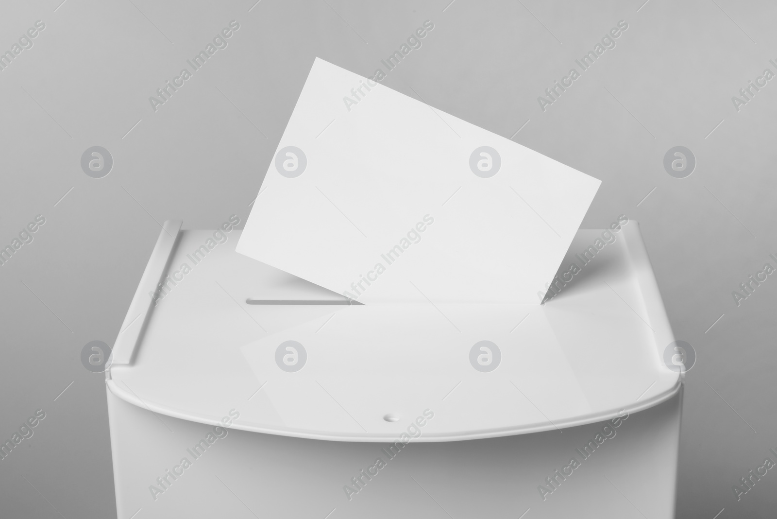 Photo of Ballot box with vote on light grey background, closeup. Election time