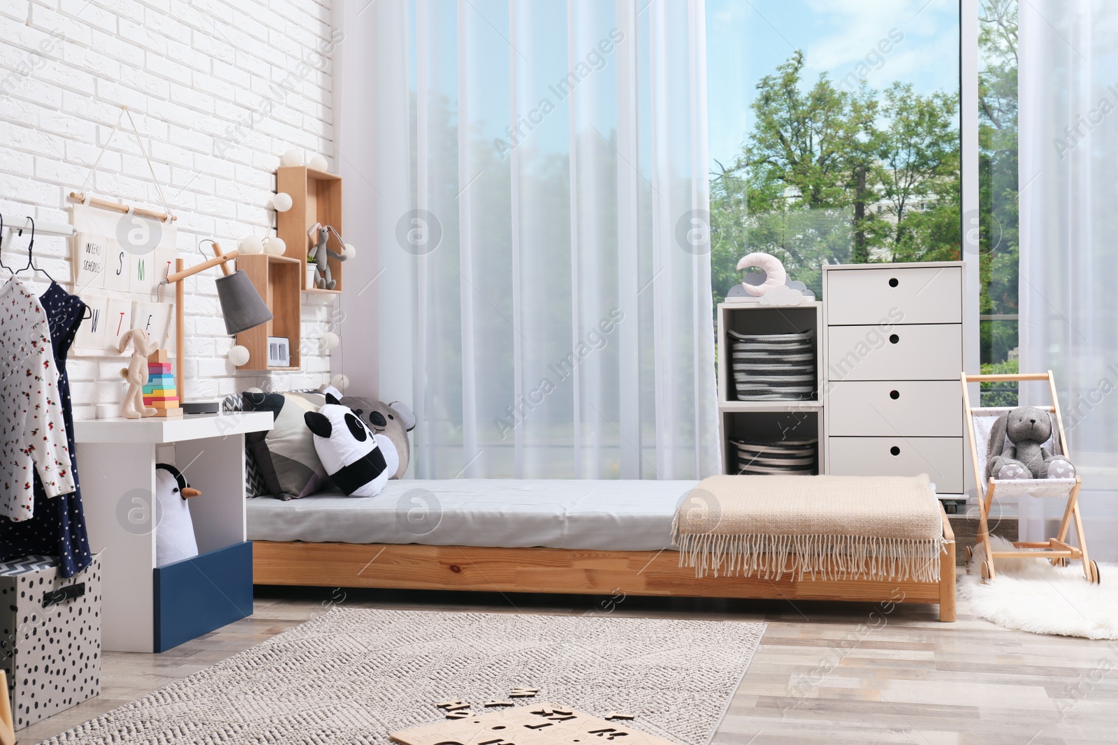 Photo of Montessori bedroom interior with floor bed and toys