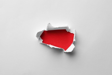 Photo of Hole in white paper on red background