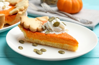 Slice of delicious homemade pumpkin pie on light blue wooden table, closeup