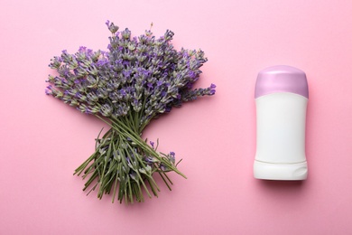 Photo of Female deodorant and lavender flowers on pink background, flat lay