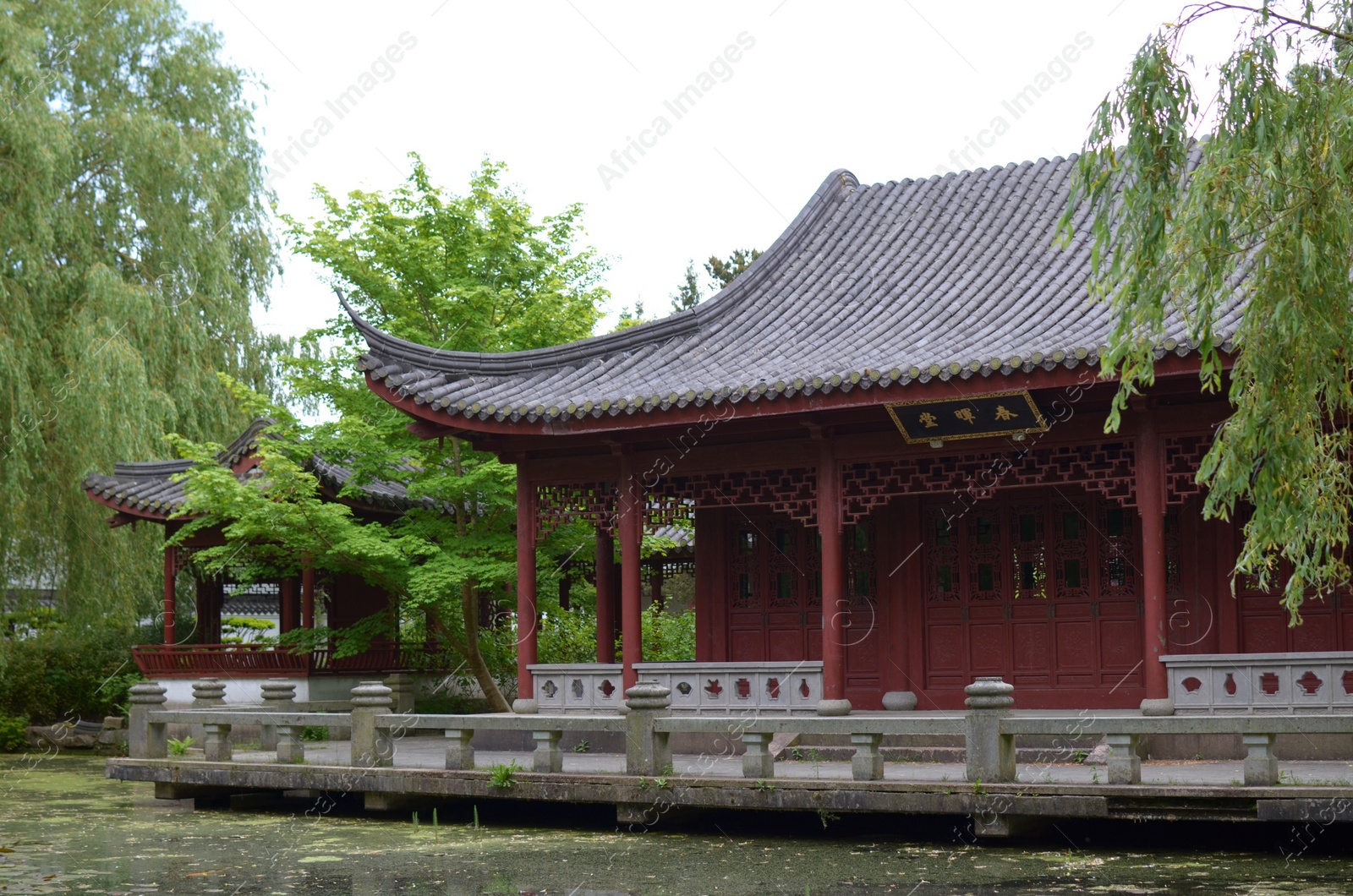 Photo of HAREN, NETHERLANDS - MAY 23, 2022: Beautiful view of oriental building near pond in Chinese garden