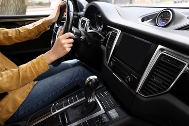 Photo of Woman using navigation system while driving her car, closeup