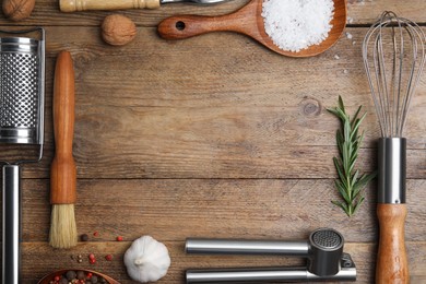 Photo of Frame made of cooking utensils and fresh ingredients on wooden table, flat lay. Space for text