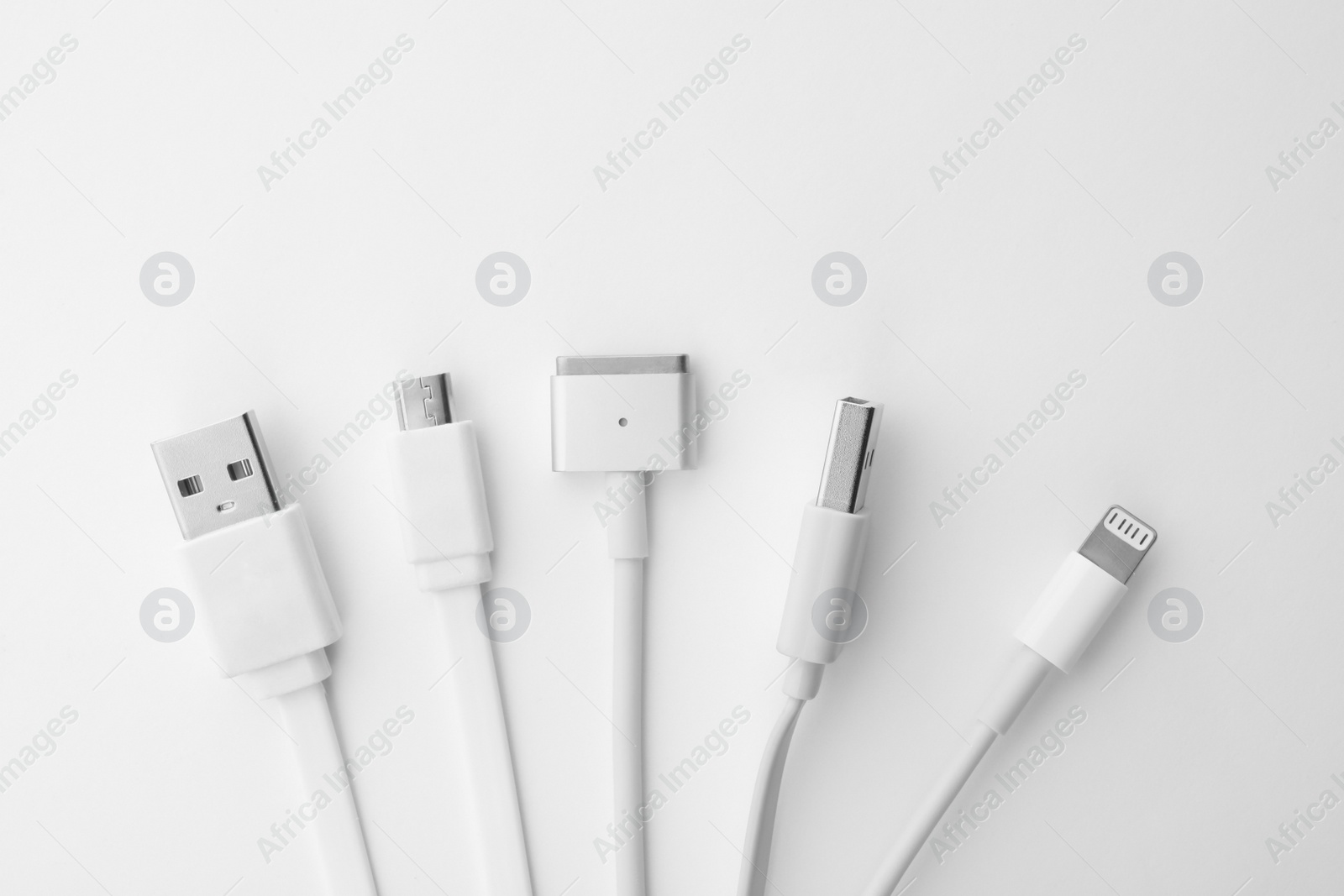 Photo of Charge cables on white background, top view. Modern technology