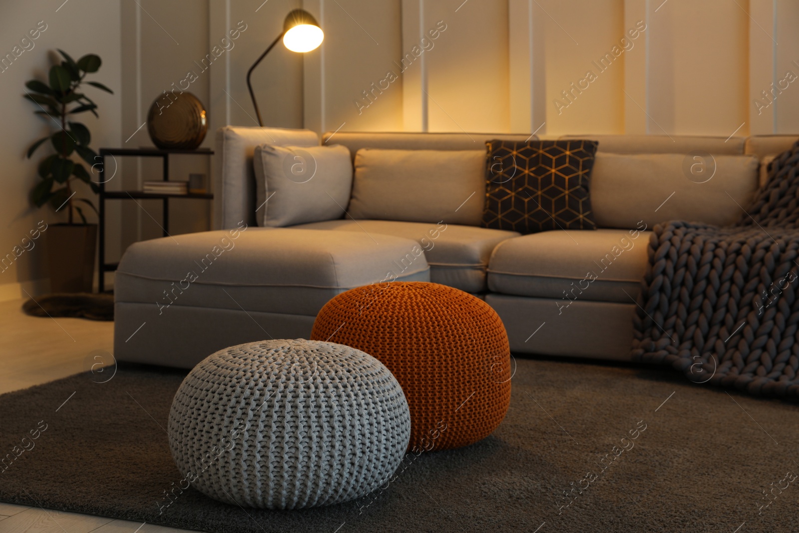 Photo of Living room interior with different stylish knitted poufs and sofa