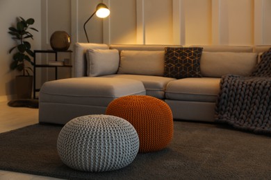 Photo of Living room interior with different stylish knitted poufs and sofa