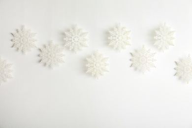 Beautiful decorative snowflakes hanging on white background, space for text