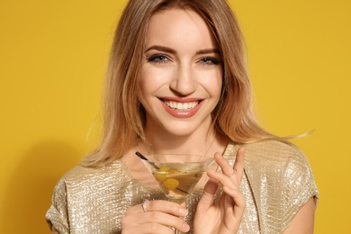Photo of Beautiful young woman with glass of martini cocktail on color background