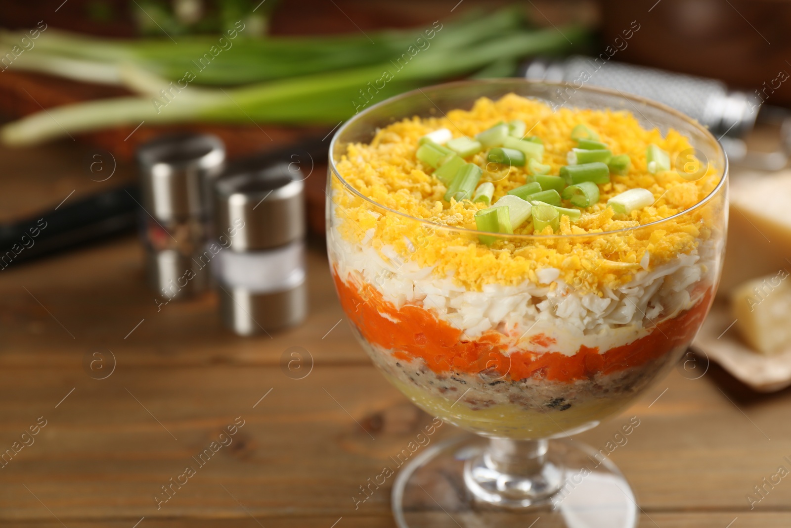 Photo of Traditional russian salad Mimosa served on wooden table. Space for text