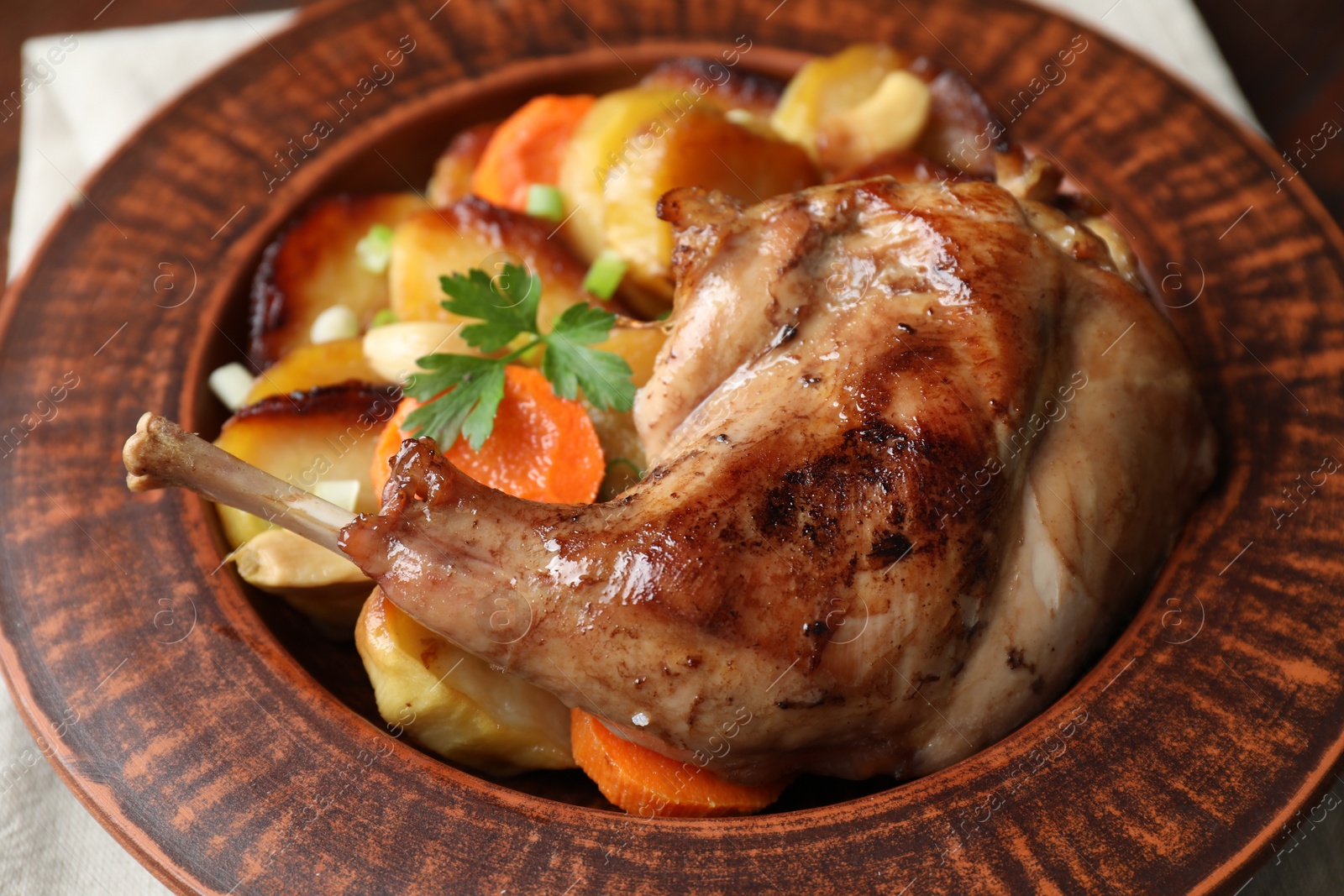 Photo of Tasty cooked rabbit meat with vegetables on table, closeup