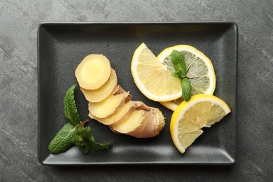 Photo of Fresh lemon, ginger and mint on grey table, top view