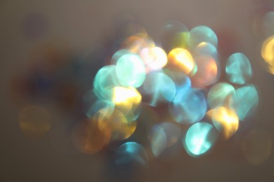 Blurred view of shiny lights on light background. Bokeh effect