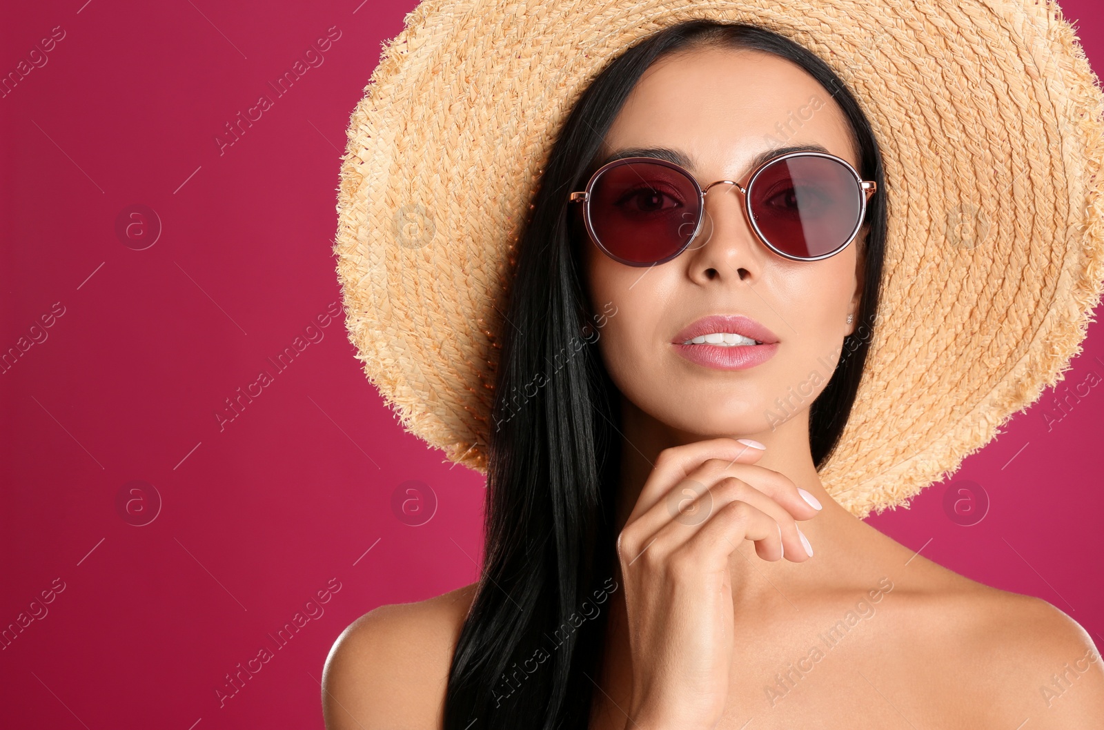 Photo of Beautiful woman wearing sunglasses on pink background