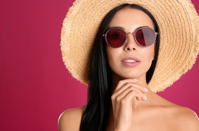 Photo of Beautiful woman wearing sunglasses on pink background