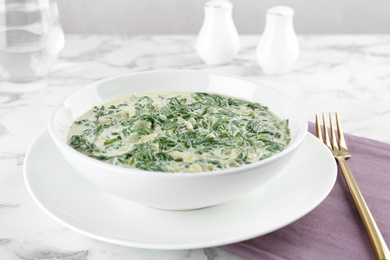 Photo of Tasty spinach dip on white marble table