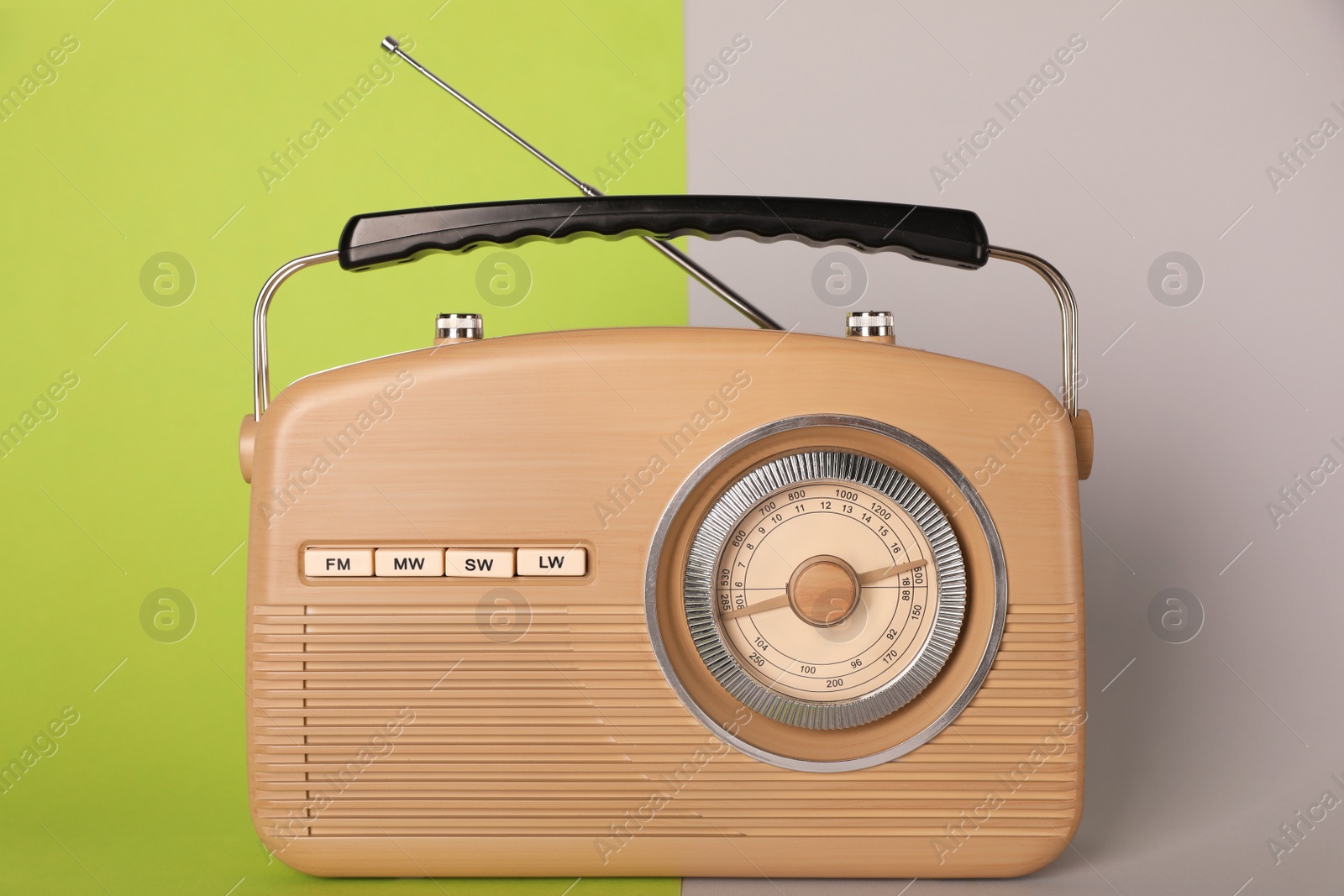 Photo of Portable retro radio receiver on color background