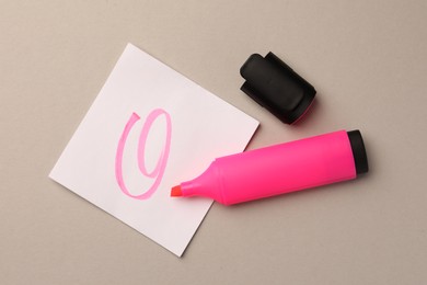 Bright pink marker and sticky note on light grey background, flat lay